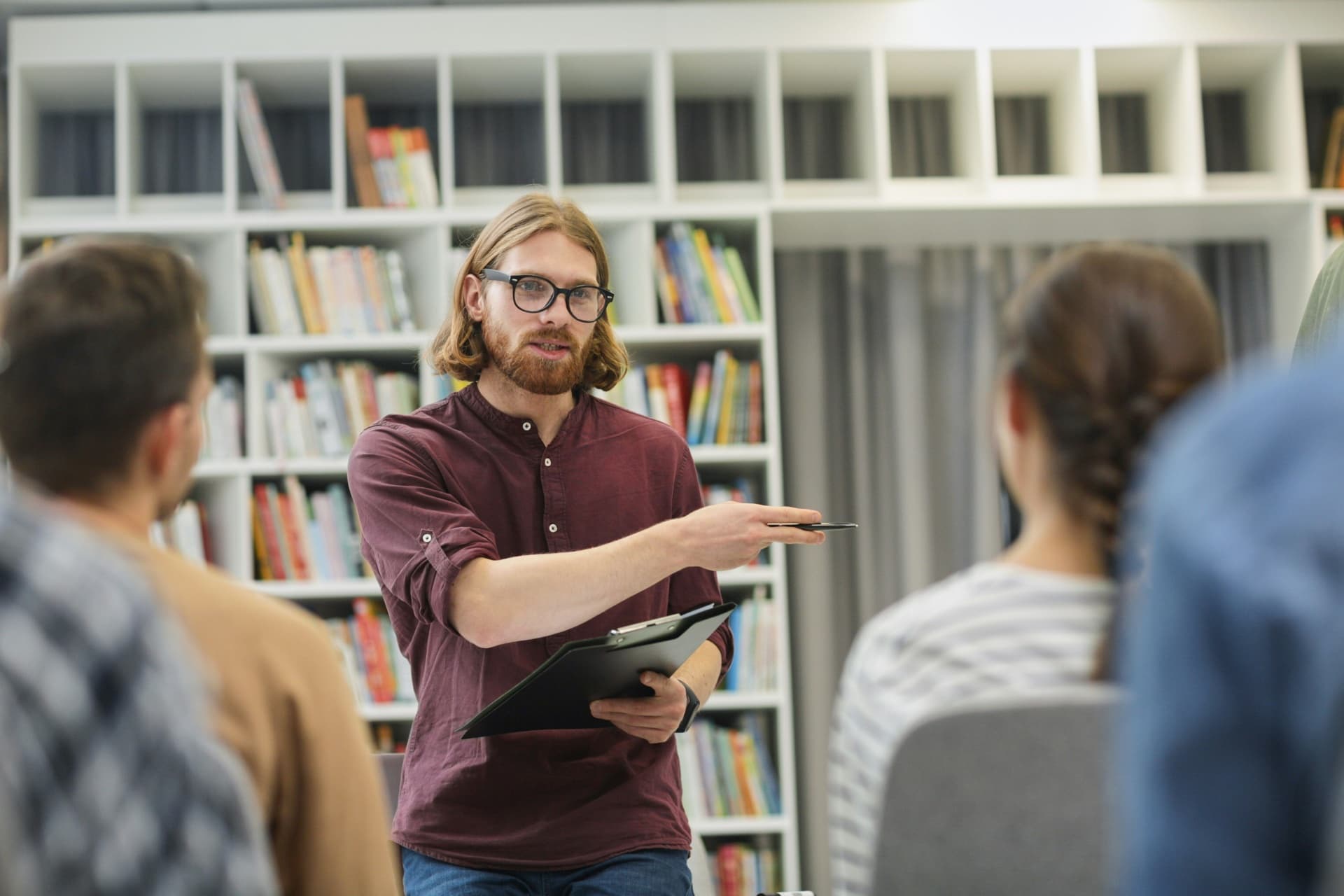 A coach leading a group discussion in a library.